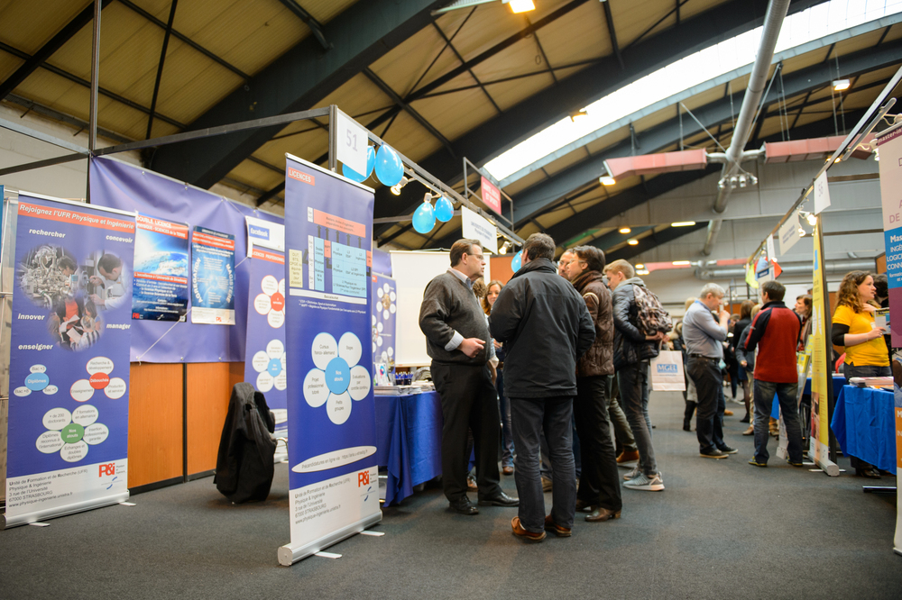 STRASBOURG, FRANCE - FEB 4, 2016: Children and teens of all ages attending annual Education Fair to choose career path and receive vocational counseling - busy stand